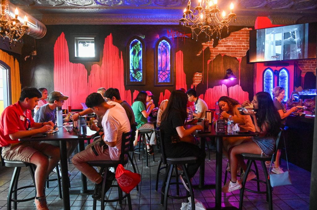 wide shot of restaurant interior. wall is painted red with black paint dripping down.