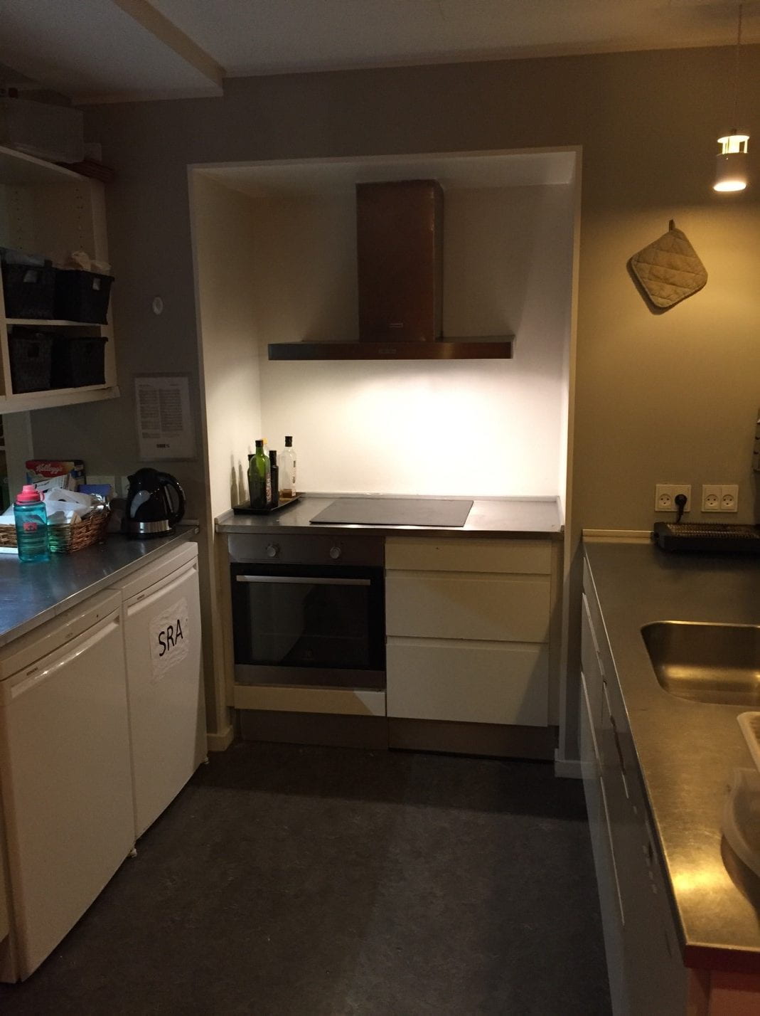 A dimly lit kitchen with white cupboards