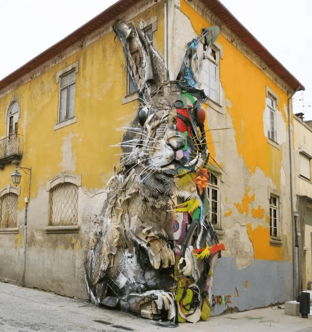 Large bunny mural on a wall on a city street made out of recycled plastic