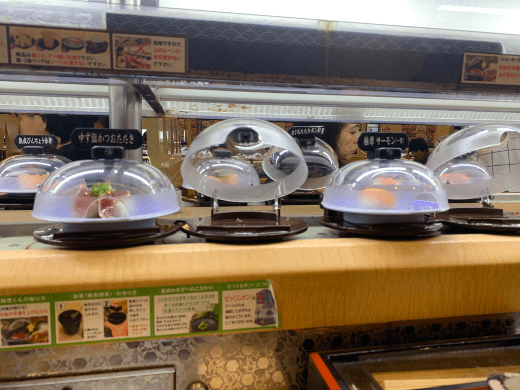 A conveyer belt with plates of various types of sushi